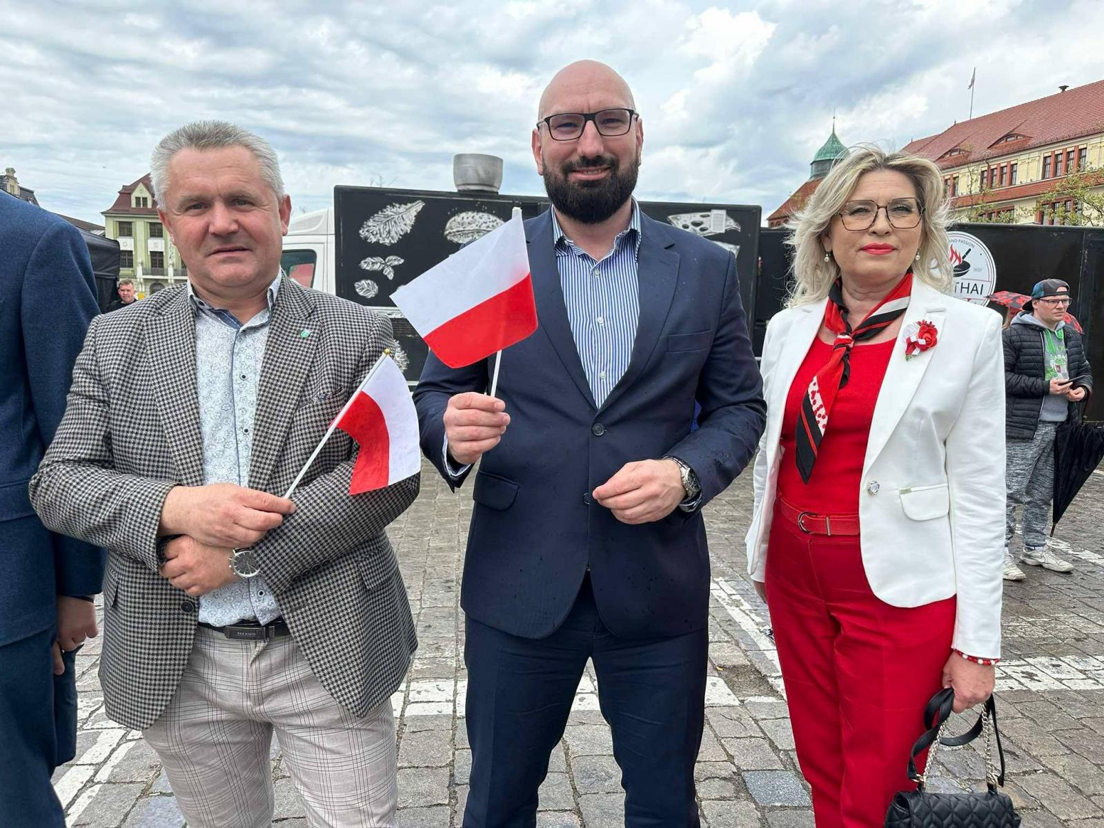 Zdjęcie z miejskich uroczystości 2 maja - Dnia Flagi RP. Na zdjecie są: starosta słupski Paweł Lisowski, członek Zarządu Powiatu Adriana Cerkowska-Markiewicz, wójt Gminy Smołdzino Arkadiusz Walach podczas obchodów.